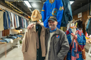 Store owner of Loope, Ian Davies, stood at the front of his store with several rails of clothing behind him.