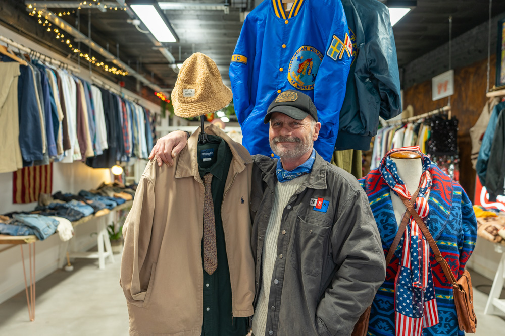 Store owner of Loope, Ian Davies, stood at the front of his store with several rails of clothing behind him.